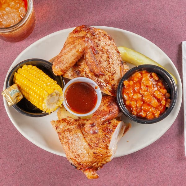 Jerry Neel's Bar-B-Q grilled chicken with corn on the cob, baked beans, and BBQ sauce.
